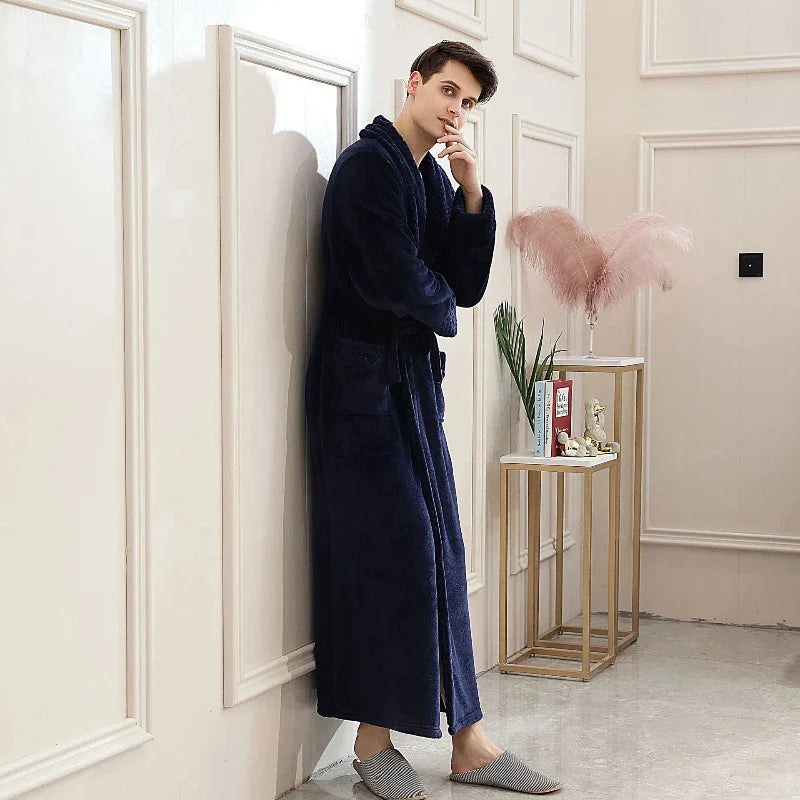 Man wearing a navy blue robe in a stylish room with decor elements.