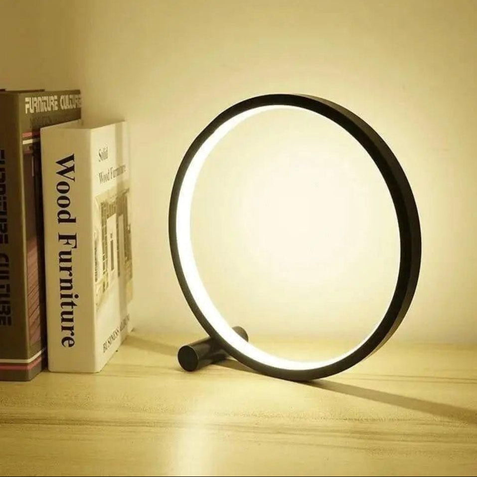 Round LED lamp on a wooden surface with books in the background