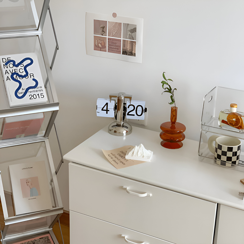 White dresser with decorative items including a calendar, vase, and mug.