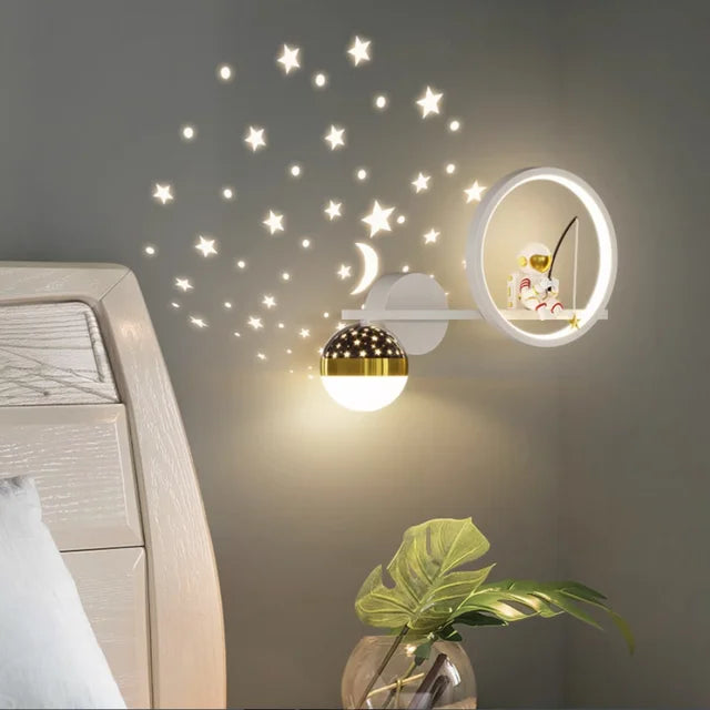 Decorative wall lights with star stickers on a wall above a bed.