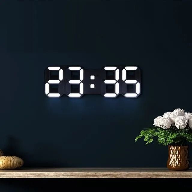 Digital clock displaying the time '23:39' on a dark wall with a vase of flowers on a shelf.