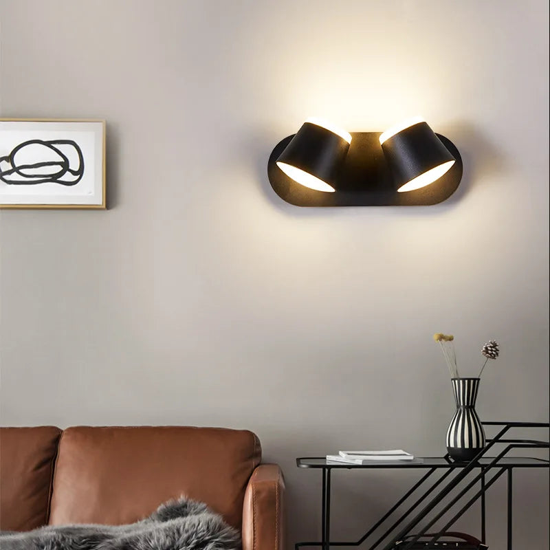 Modern wall light fixture in a living room setting with a brown sofa and decorative elements.