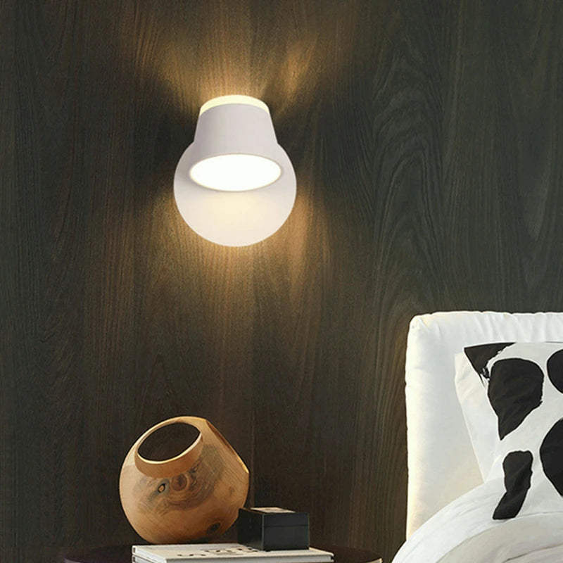 Wall-mounted light fixture casting a warm glow in a bedroom setting.