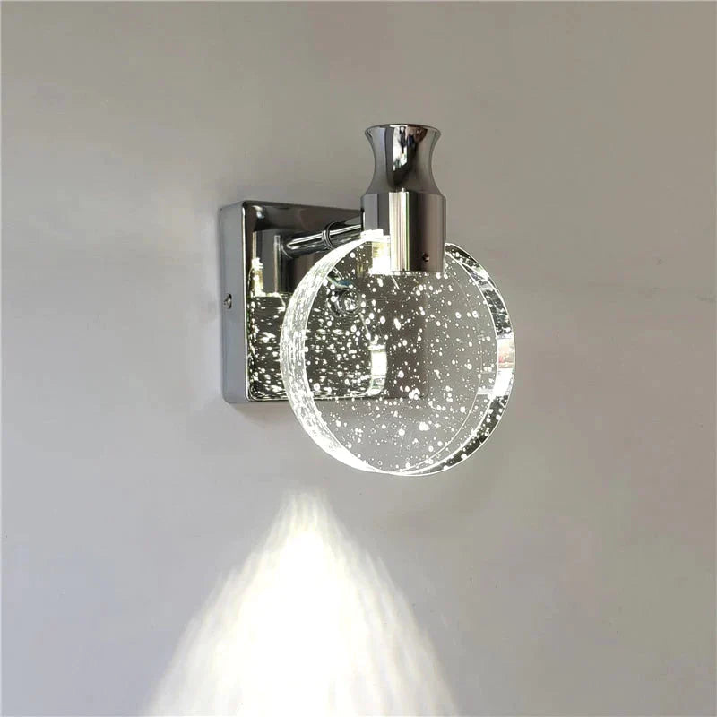 Wall-mounted light fixture with a glass cover on a plain wall.