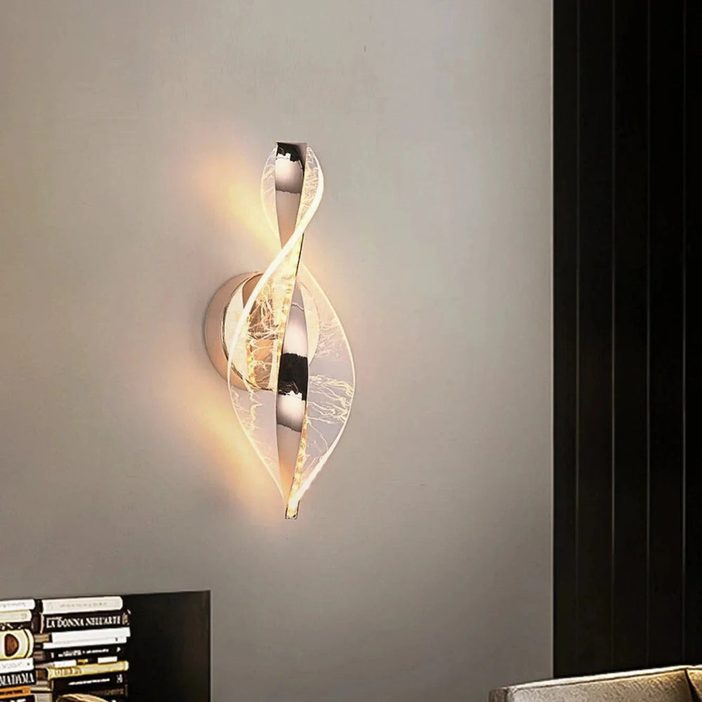 Modern wall sconce with a swirling design on a gray wall.