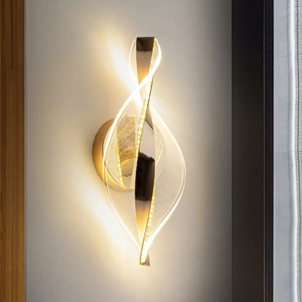 Modern wall lamp with gold finish on a white wall