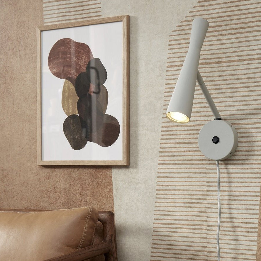 Wall-mounted lamp next to abstract art on a textured wall