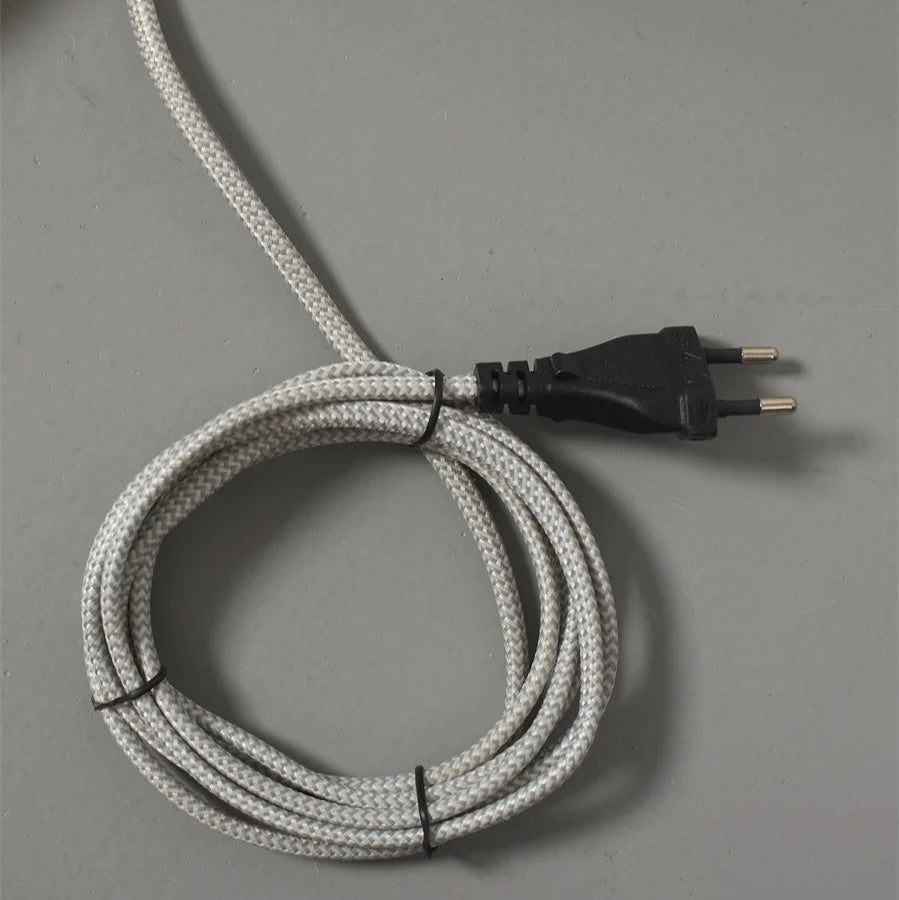 Coiled electrical cable with a plug on a gray background