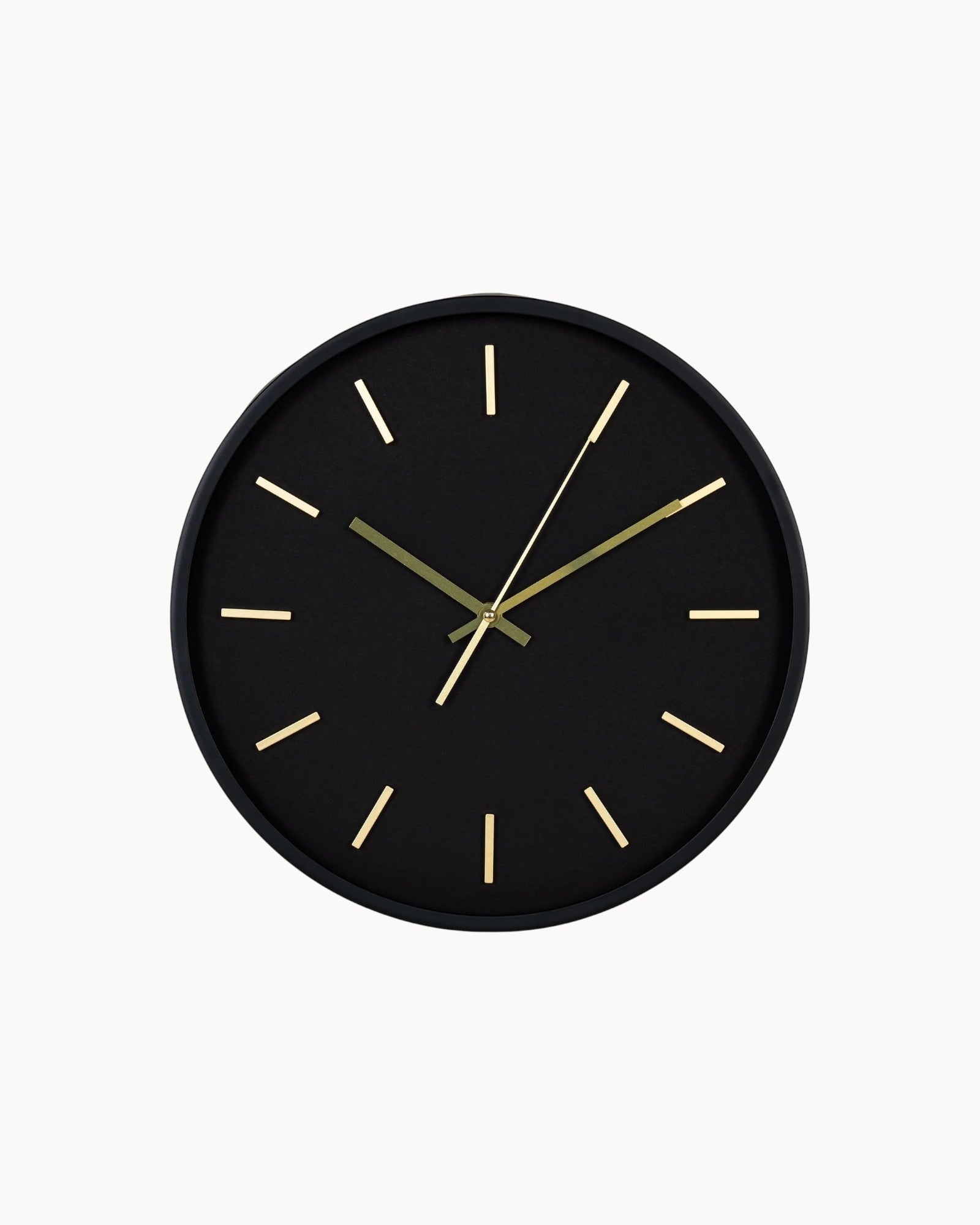 Black wall clock with gold hands on a white background