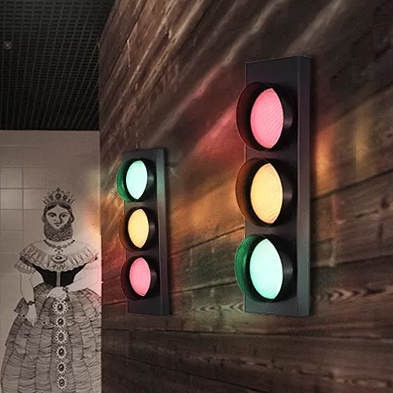 Traffic light-style wall lights on a wooden wall with a decorative illustration of a woman on the left.