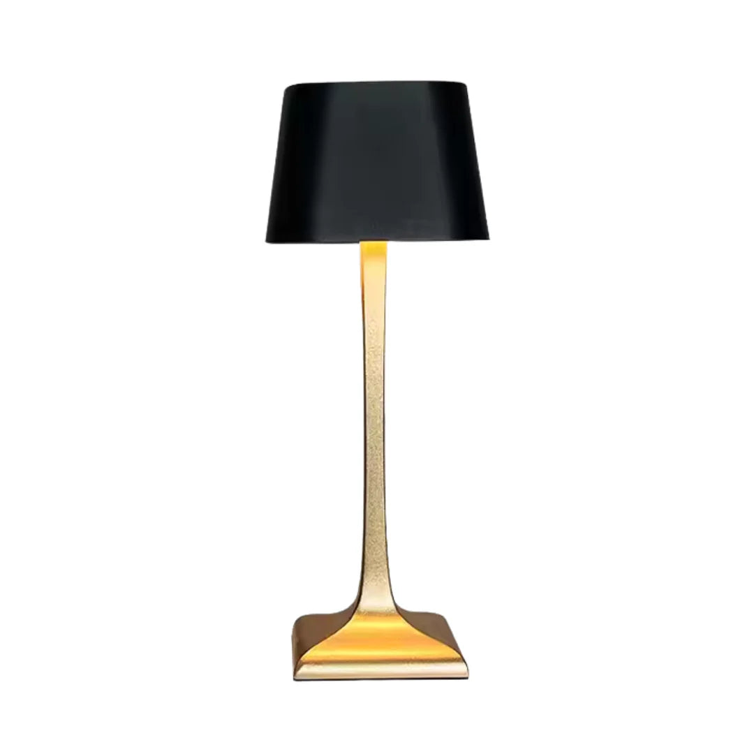 Modern table lamp with black shade and gold base on a white background