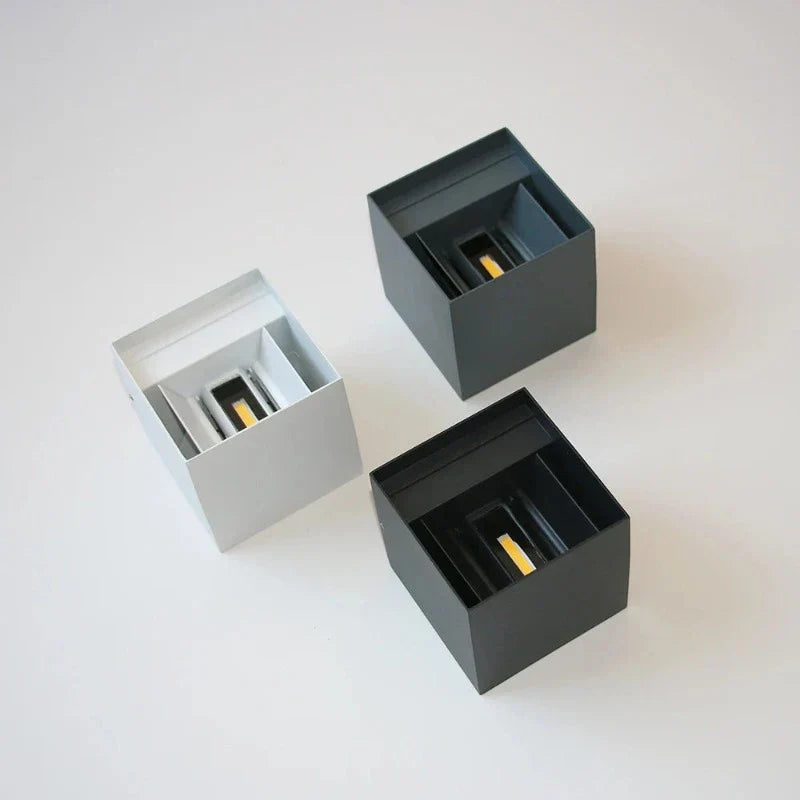 Three square boxes in gray, black, and silver on a white background
