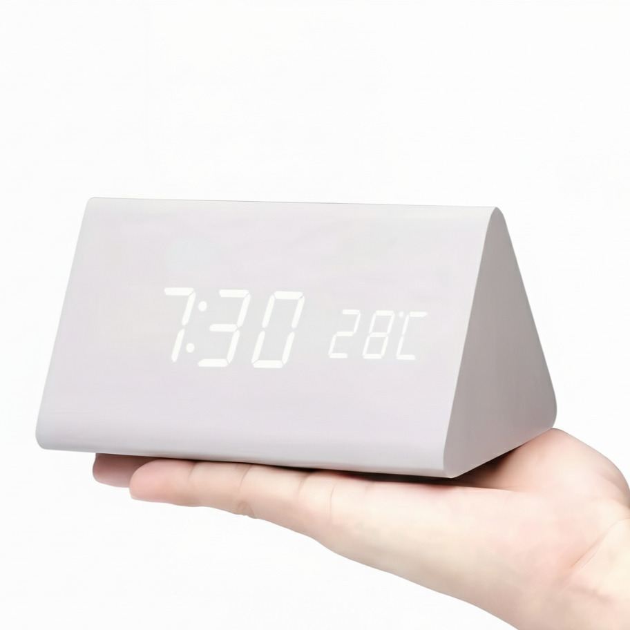 White triangular digital clock held in a hand with a white background