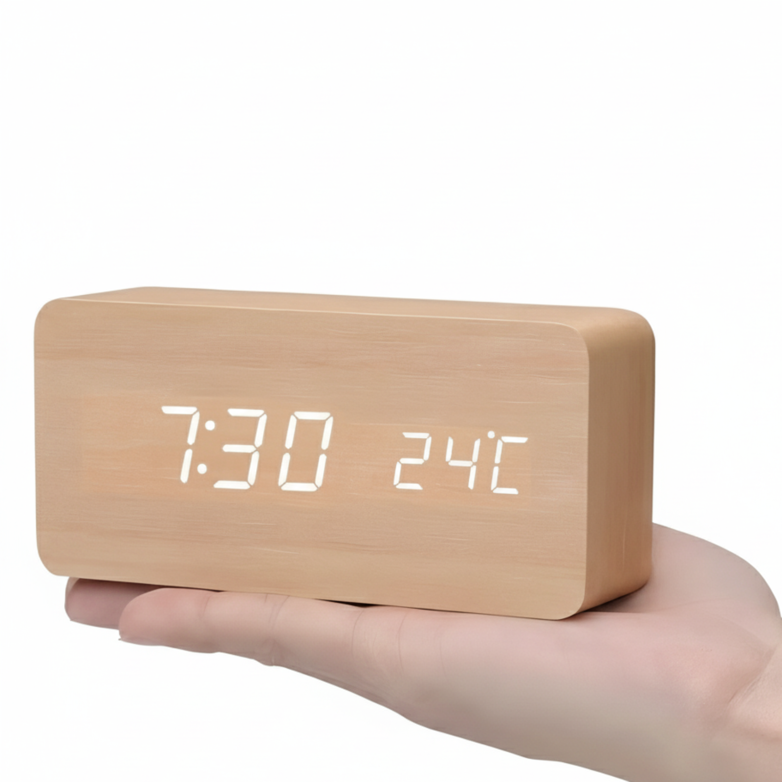 Wooden digital clock with LED display held in a hand on a white background