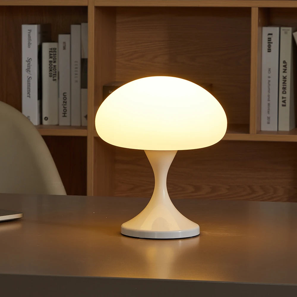 Mushroom-shaped table lamp on a desk with books in the background
