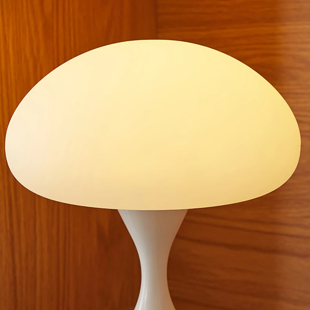 Mushroom-shaped lamp with a white base on a wooden surface