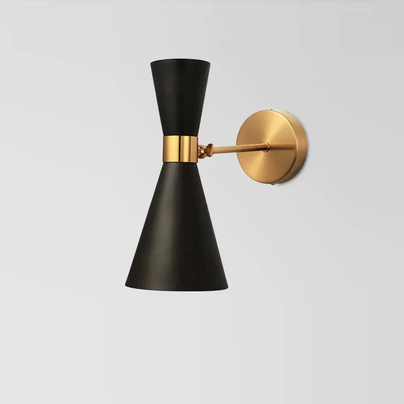 Wall-mounted lamp with black conical shade and gold arm on a light gray background