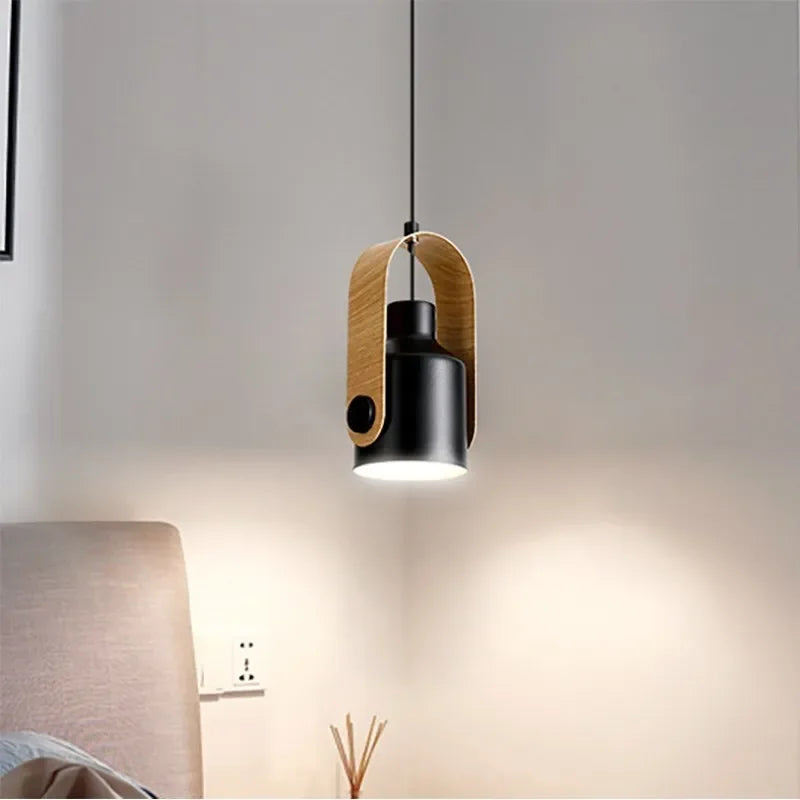 Modern pendant light with black fixture and wooden accents hanging in a room.