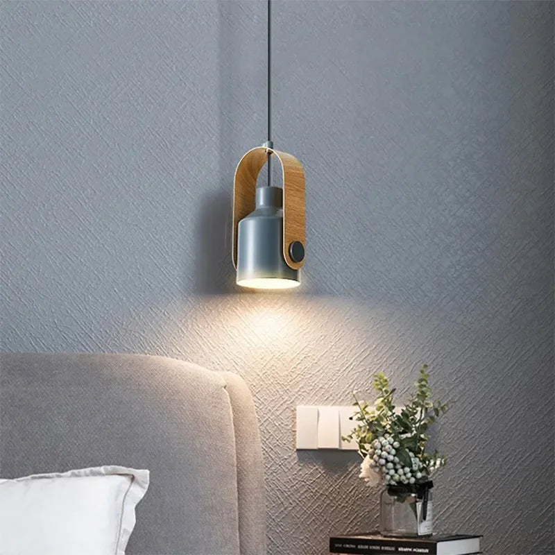 Modern pendant light fixture on a textured wall above a bed.