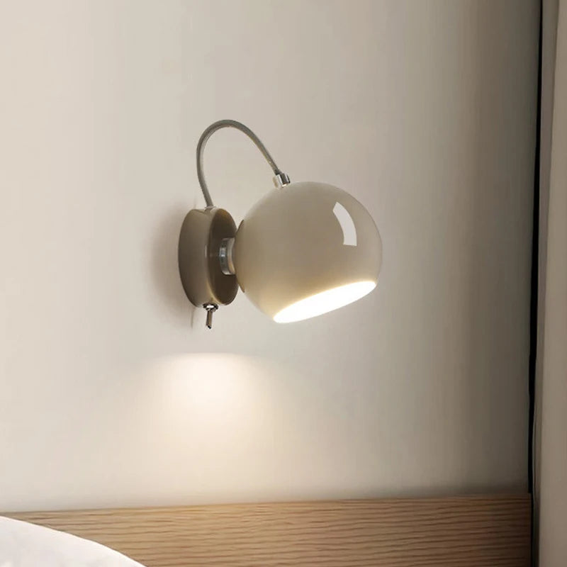 Wall-mounted lamp with a beige shade on a neutral wall.
