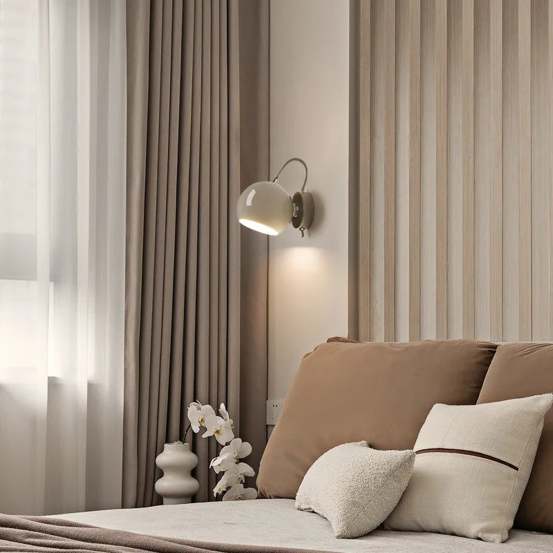 Neatly made bed with pillows and a lamp in a bedroom setting