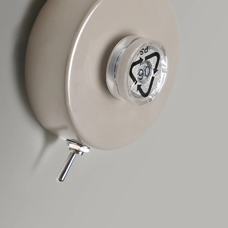 Close-up of a white reel with a clear plastic cap featuring a black logo on a gray background