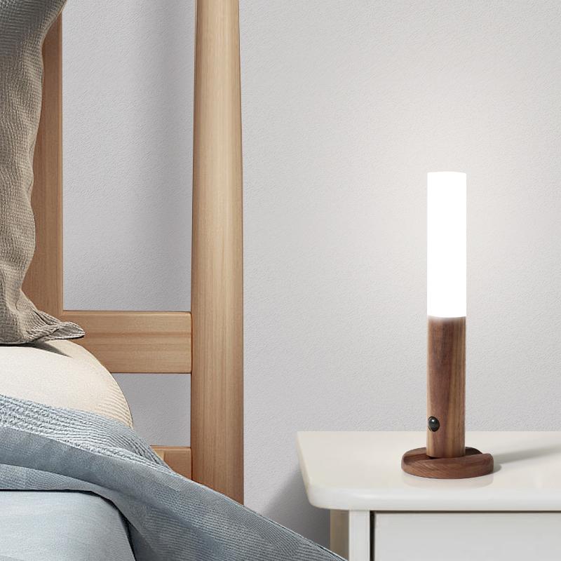 Modern bedside lamp on a nightstand next to a bed with wooden headboard