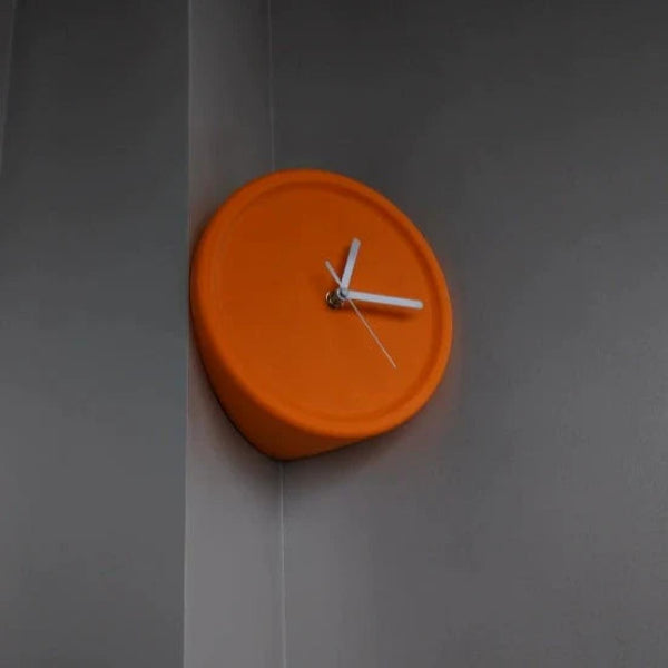 Orange wall clock on a gray wall