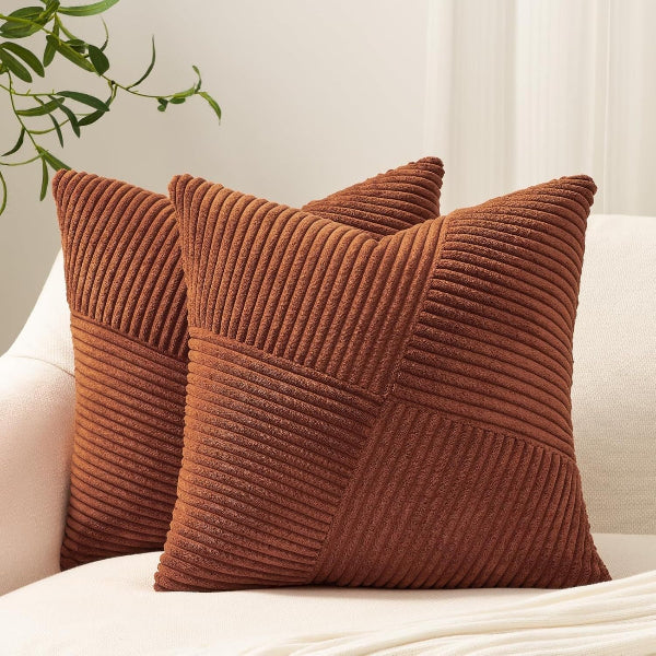Two brown textured pillows on a white couch with a light background