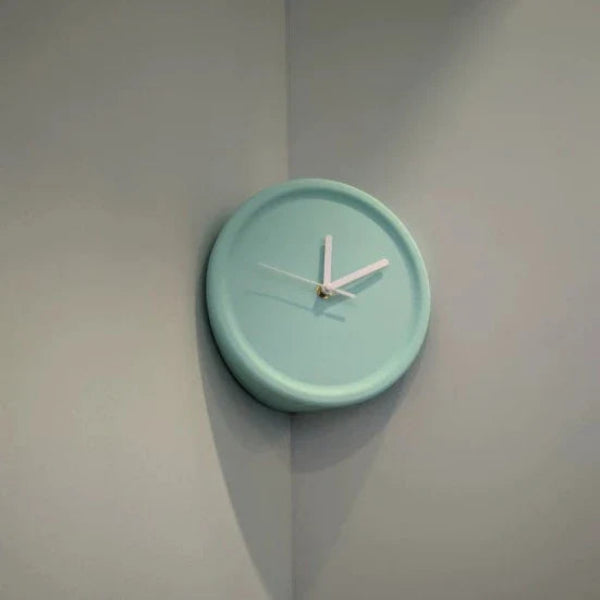 Mint green wall clock on a light gray wall
