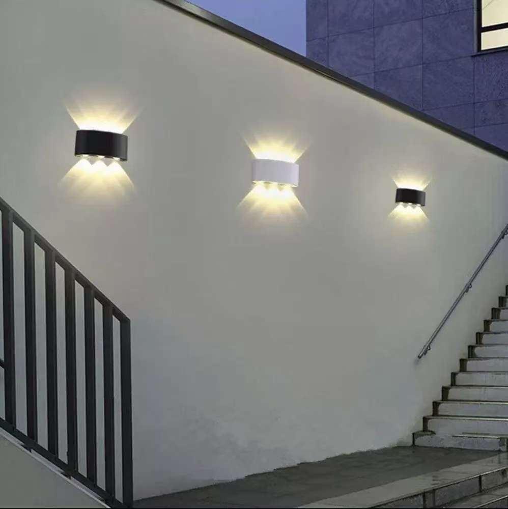 Outdoor wall lights on a building exterior with stairs and railing.