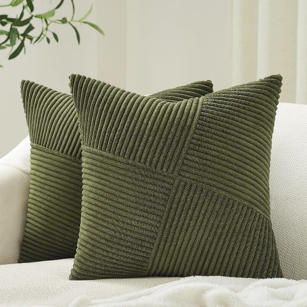 Two green textured pillows on a white sofa with a neutral background