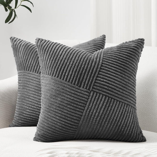 Two gray textured pillows on a white surface with a light background
