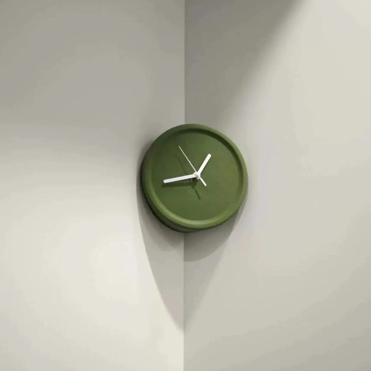 Green wall clock on a light gray wall