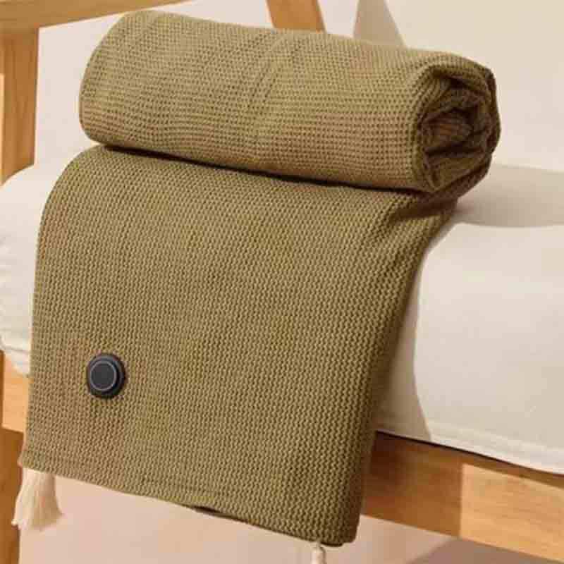 Folded green blanket with a button on a white surface