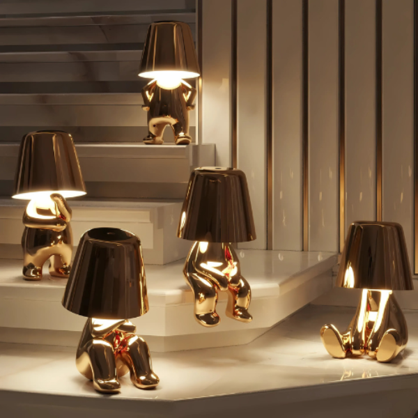 Gold and black decorative lamps on a reflective surface with a mirror background
