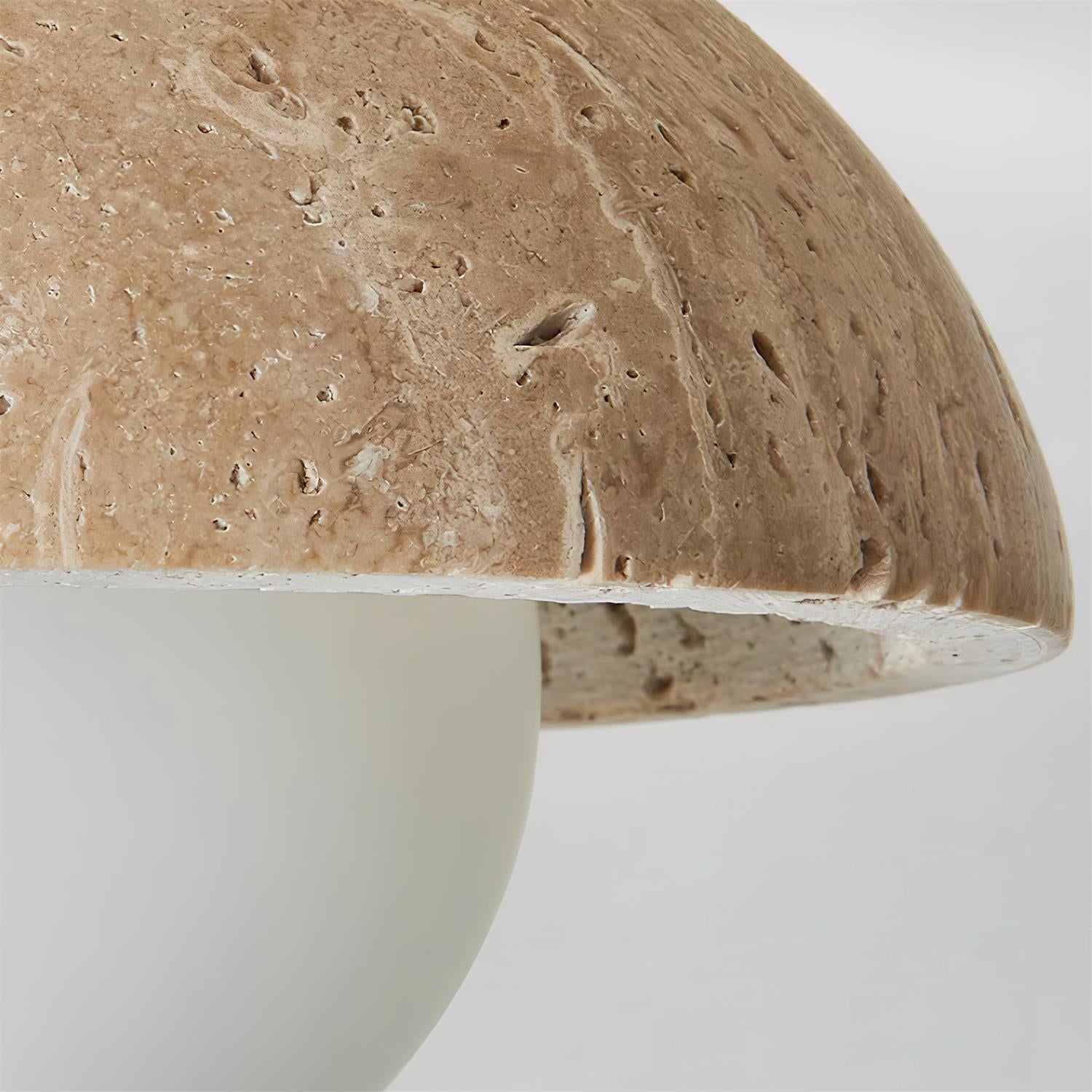 Close-up of a textured ceramic mushroom-shaped object on a white background
