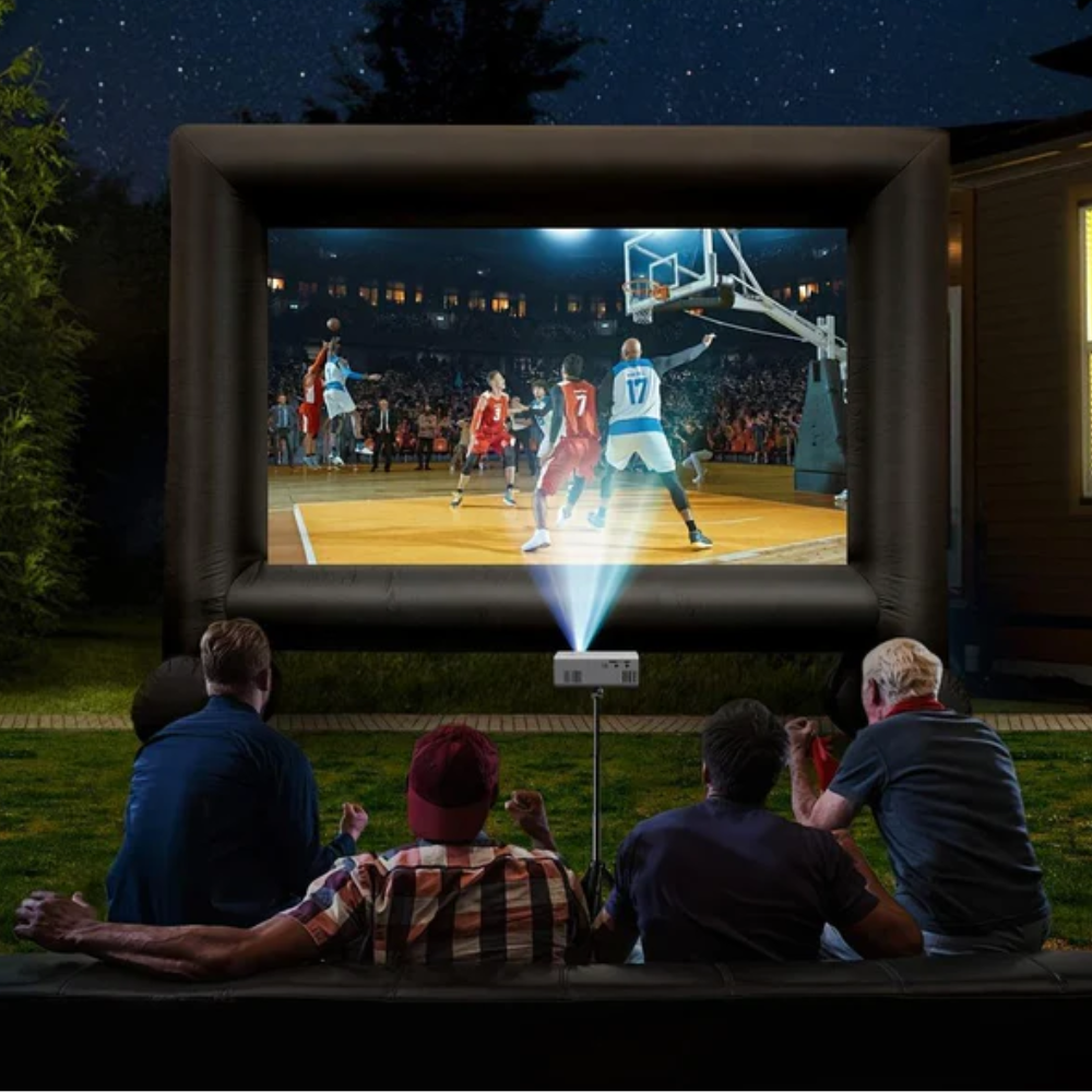 Inflatable outdoor movie screen displaying a basketball game with people watching.