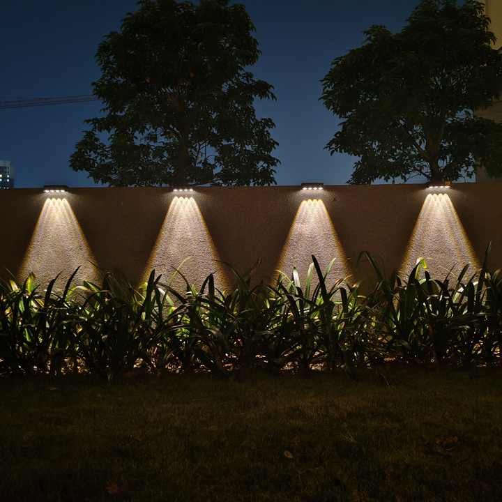 Outdoor wall lights illuminating a garden at night