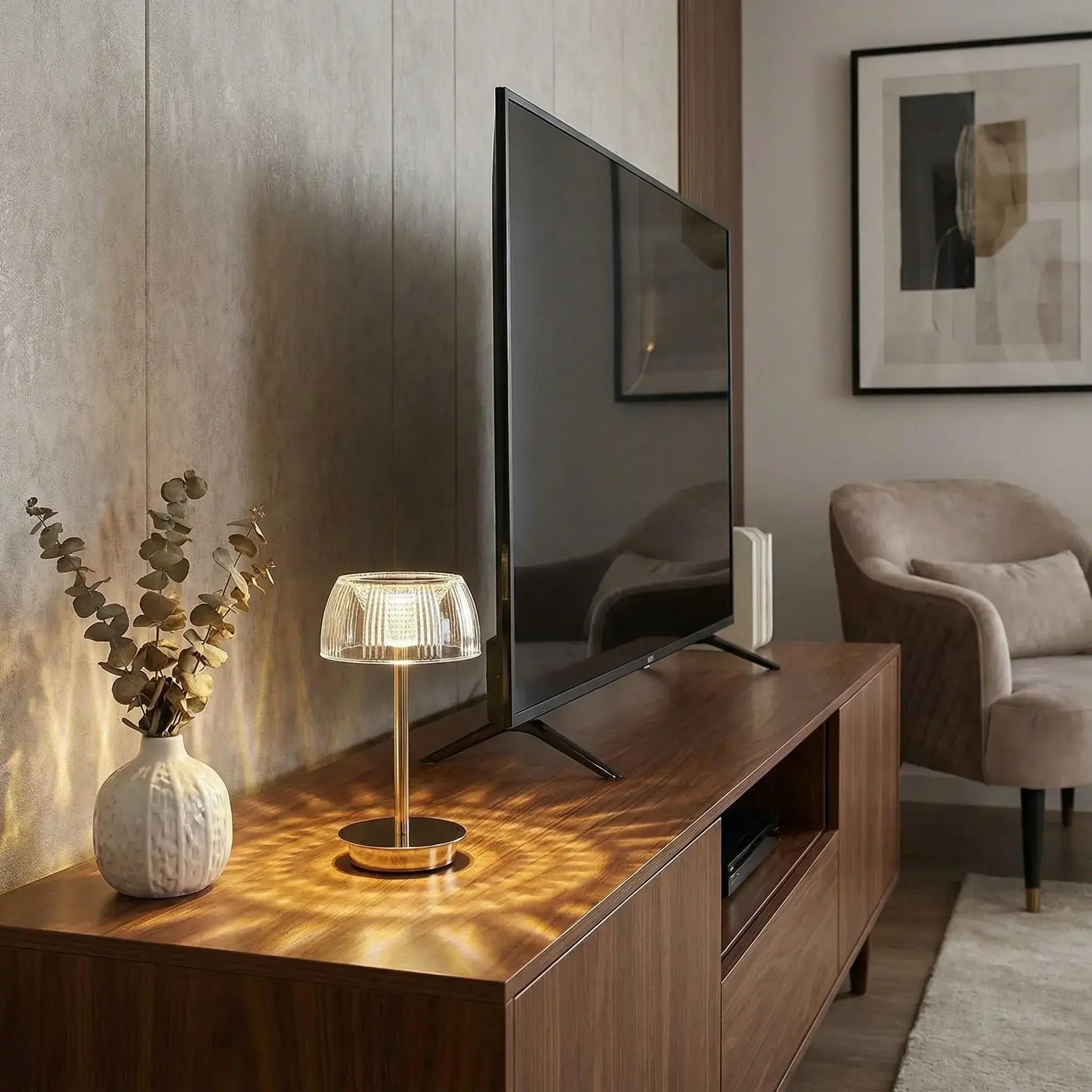 Modern living room with a television, lamp, and decorative items on a wooden cabinet.