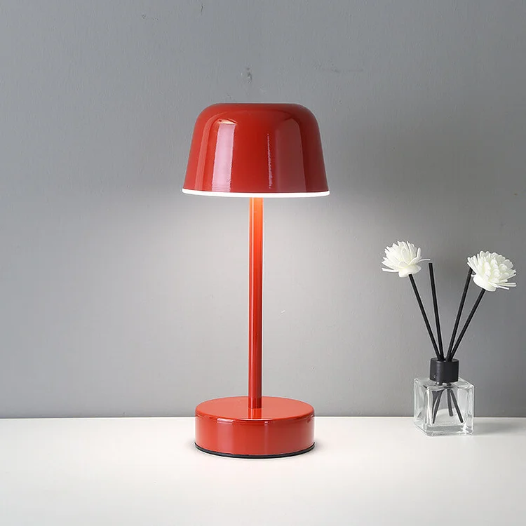 Red table lamp on a white surface with a gray background