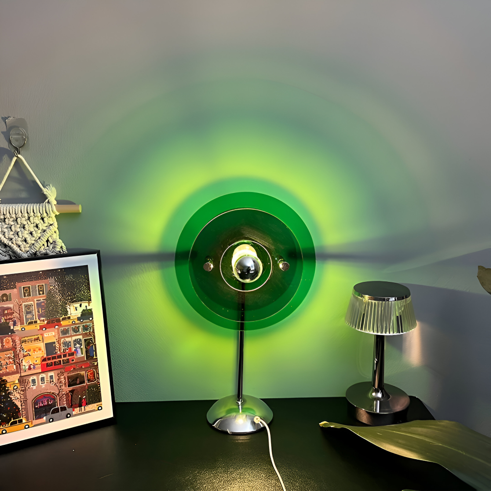 Lamp with green light projection on a wall next to a framed picture