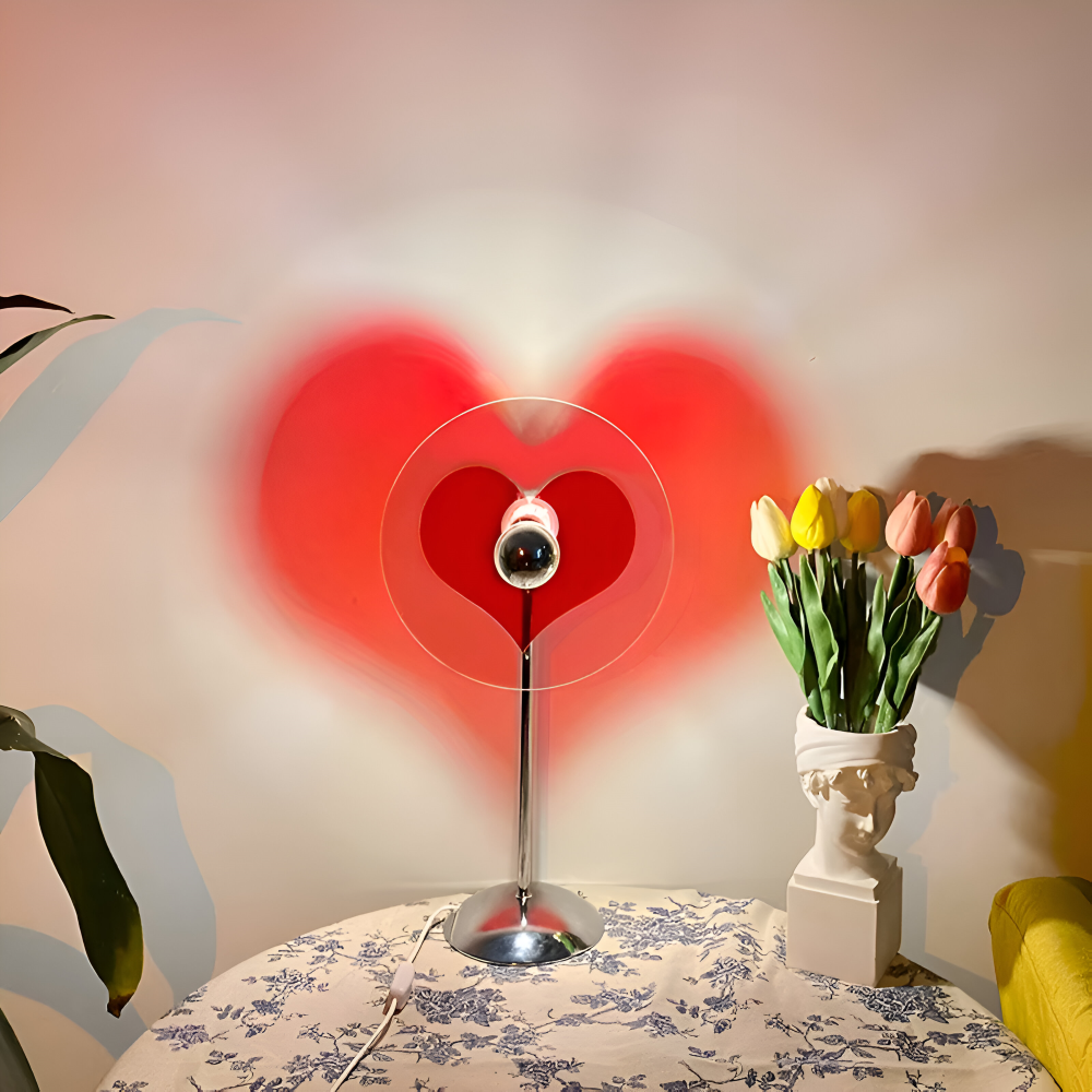 Heart-shaped light fixture on a table with a vase of tulips in the background