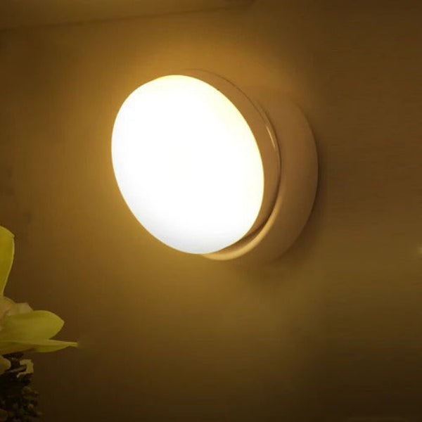 Round wall light fixture on a beige wall with a soft glow