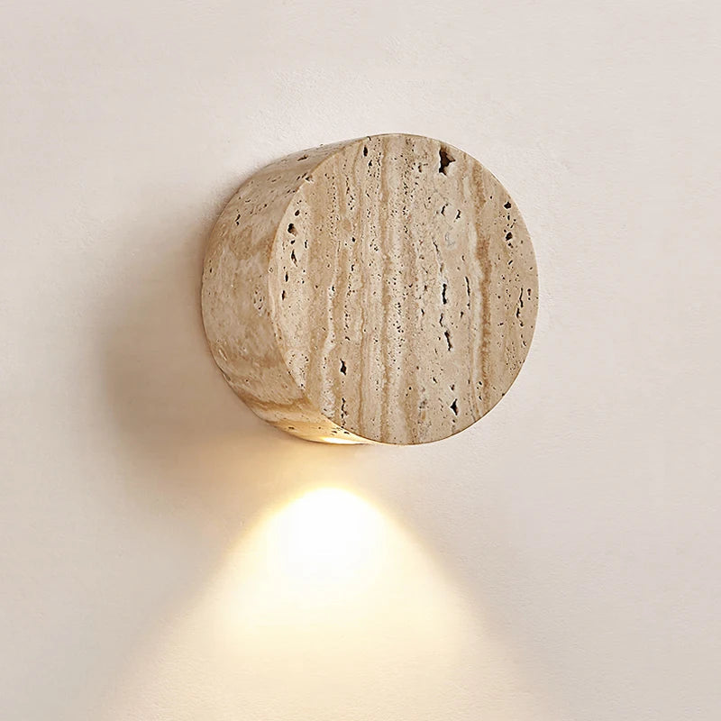 Round stone-like wall light fixture on a neutral background
