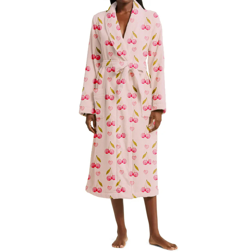 Person wearing a pink robe with cherry pattern on a white background