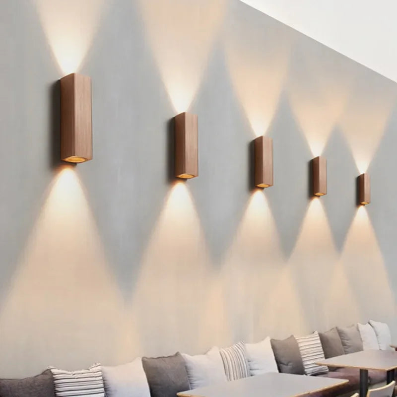 Modern wall lights on a gray wall with a sofa in the foreground
