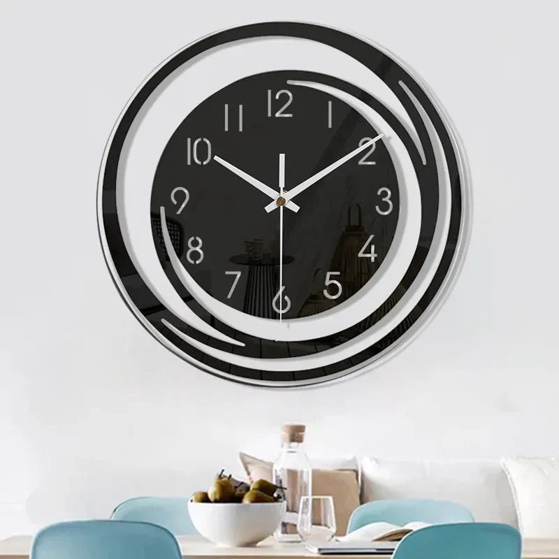 Modern wall clock with black face and white hands on a white wall.