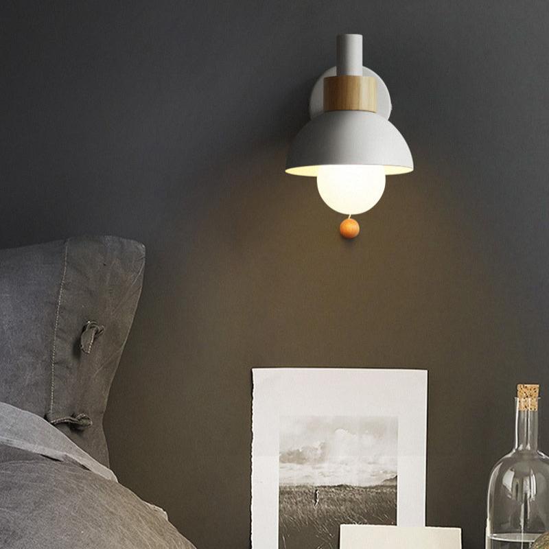 Modern wall lamp on a dark wall with a sofa and decorative items in the foreground