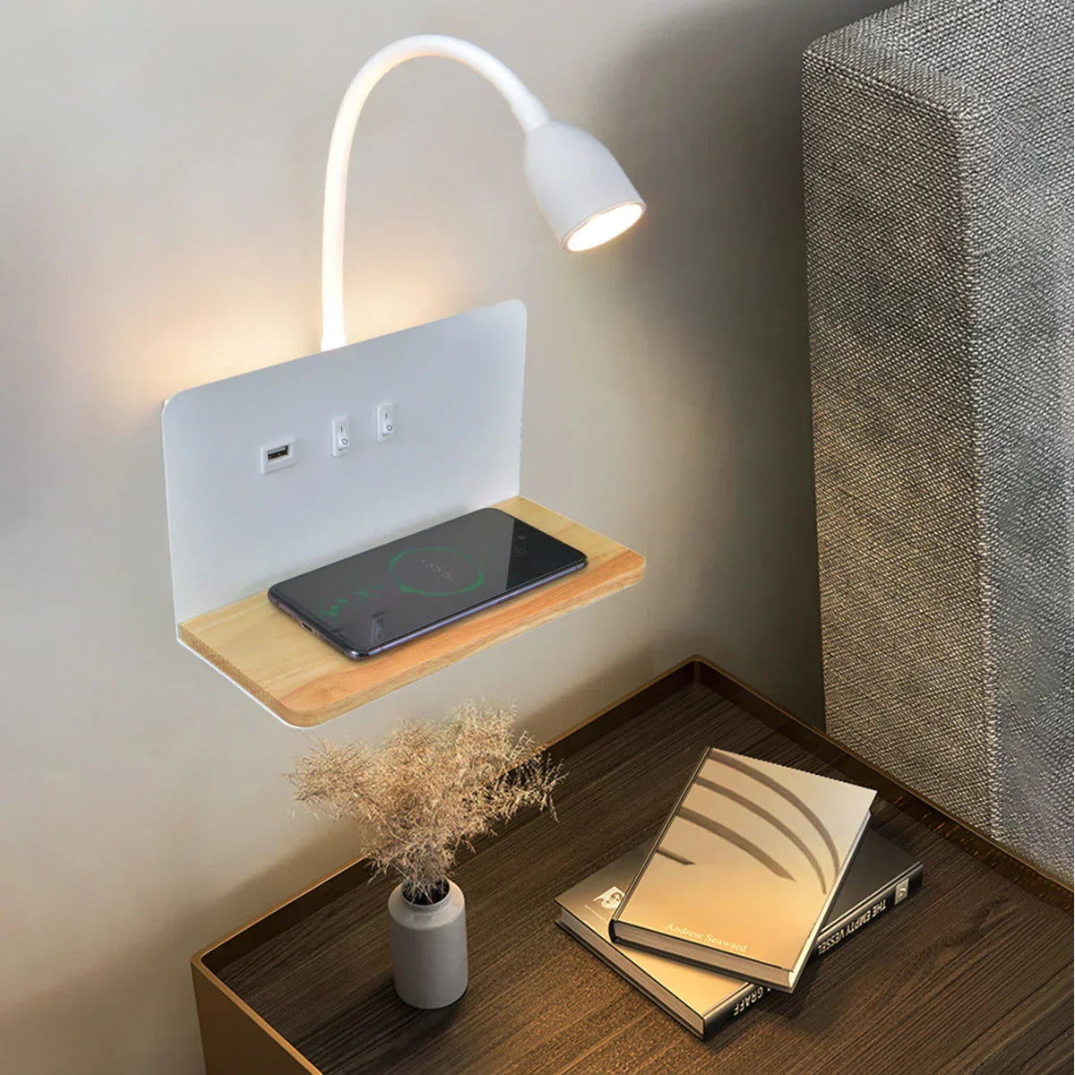 Wall-mounted reading lamp with a wooden shelf and smartphone on a wooden desk.